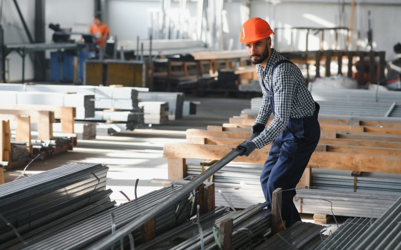 Factory worker measures the metal profile.